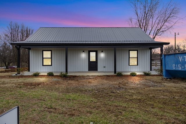 view of front of home with a porch and a lawn