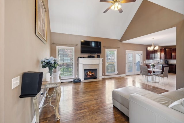 living room featuring sink, high vaulted ceiling, dark hardwood / wood-style floors, a high end fireplace, and french doors