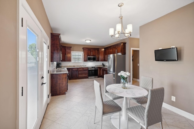 tiled dining room featuring sink and an inviting chandelier