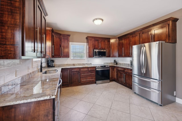 kitchen featuring light stone counters, appliances with stainless steel finishes, sink, and light tile patterned floors