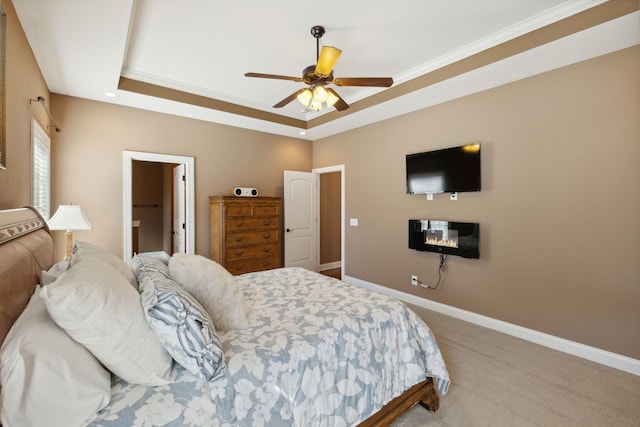 bedroom featuring crown molding, carpet floors, ceiling fan, and a tray ceiling