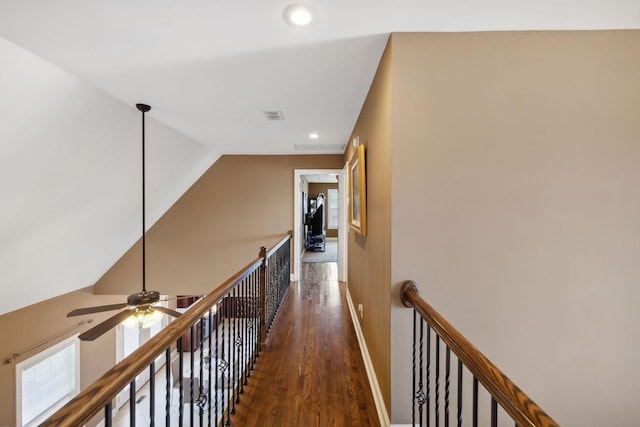 hallway with dark wood-type flooring and vaulted ceiling