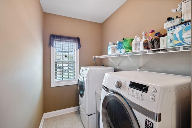 laundry room with light tile patterned flooring and washing machine and clothes dryer