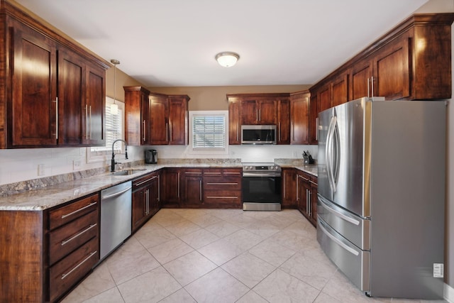 kitchen featuring sink, hanging light fixtures, stainless steel appliances, light stone counters, and light tile patterned flooring