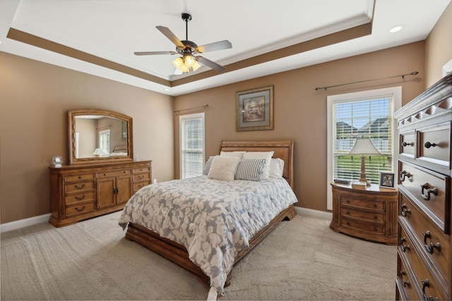 carpeted bedroom with ornamental molding, a raised ceiling, and ceiling fan