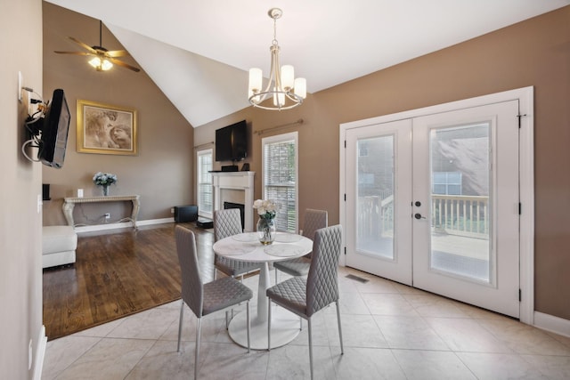 tiled dining room featuring french doors, a chandelier, and high vaulted ceiling