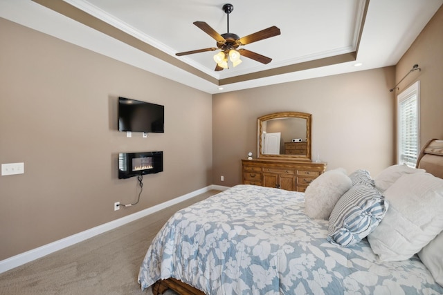 bedroom with ornamental molding, carpet flooring, ceiling fan, and a tray ceiling