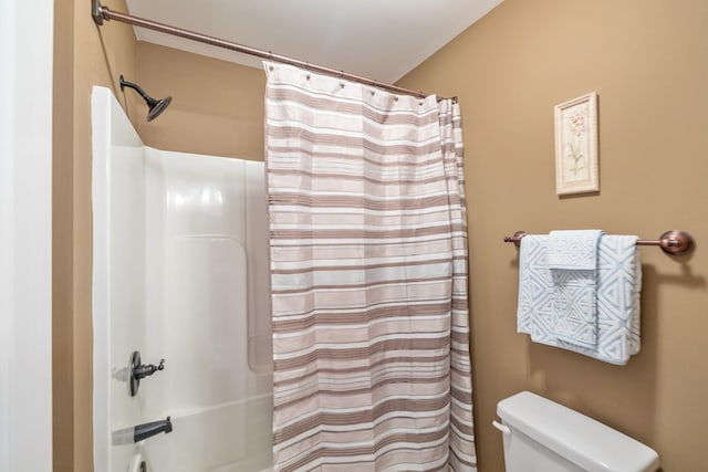 bathroom featuring shower / tub combo and toilet