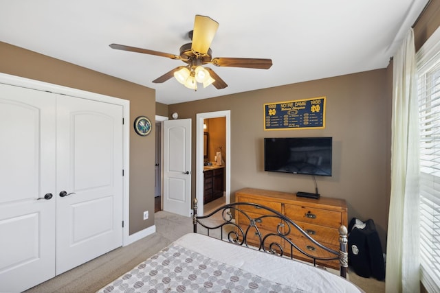 bedroom with ceiling fan, ensuite bath, light carpet, and a closet