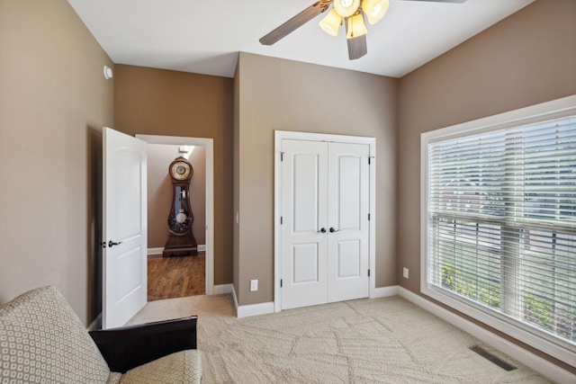 carpeted bedroom featuring a closet and ceiling fan