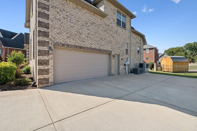 view of side of home with central AC unit and a garage