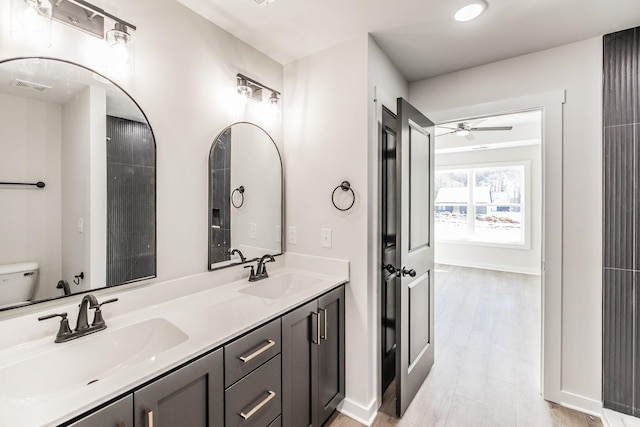 bathroom with vanity, ceiling fan, wood-type flooring, and toilet