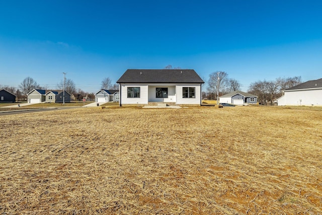 back of property featuring a yard and a garage