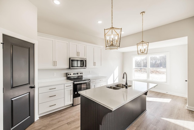 kitchen featuring sink, a center island with sink, white cabinets, and appliances with stainless steel finishes