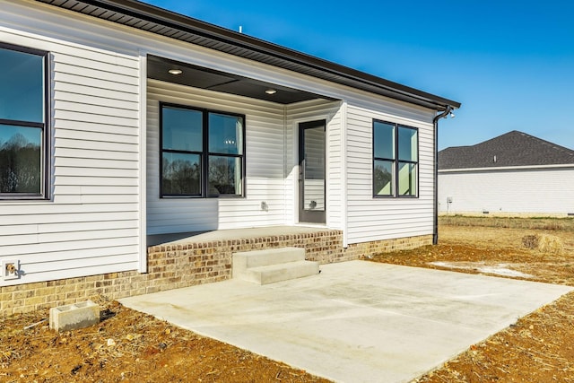 view of exterior entry with a patio