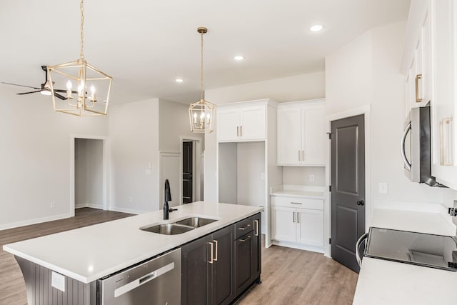 kitchen with stainless steel appliances, hanging light fixtures, sink, and white cabinets