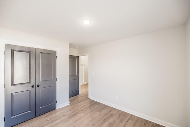 unfurnished bedroom featuring a closet and light wood-type flooring