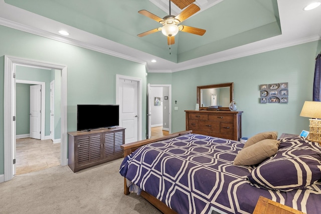 carpeted bedroom featuring ornamental molding, ceiling fan, and a tray ceiling