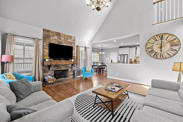 living room featuring plenty of natural light, light wood-type flooring, and a notable chandelier