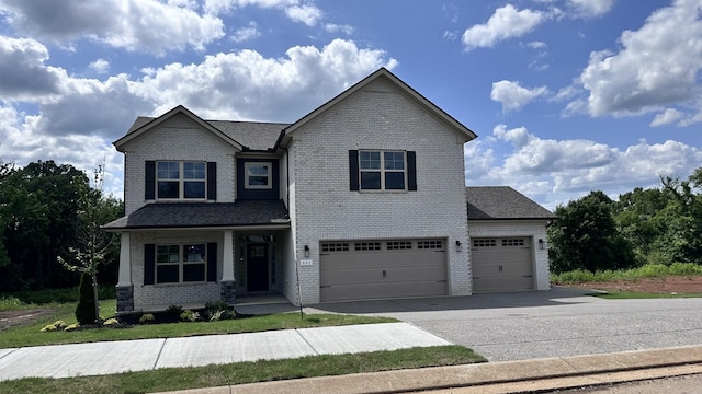 view of front of house featuring an attached garage, a shingled roof, aphalt driveway, and brick siding