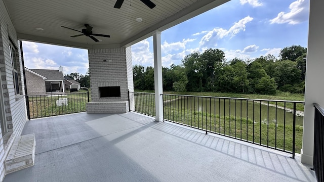 balcony with ceiling fan and a brick fireplace