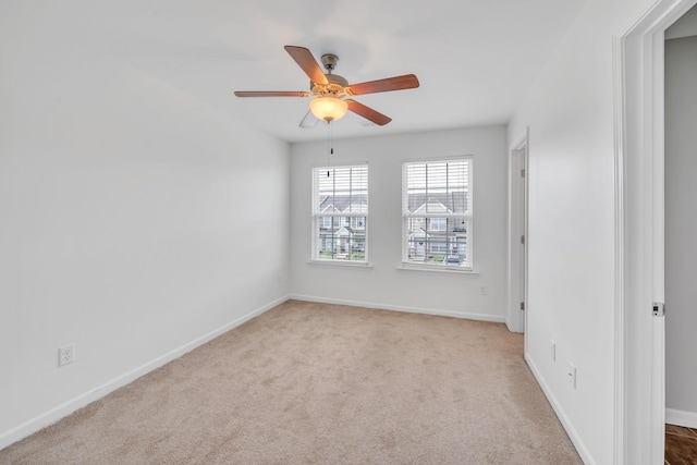 carpeted spare room featuring ceiling fan