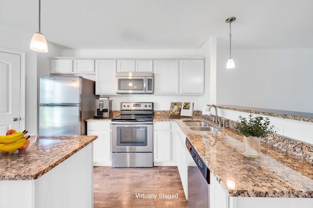 kitchen with white cabinetry, stainless steel appliances, decorative light fixtures, and sink