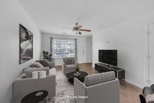 living room with wood-type flooring and ceiling fan