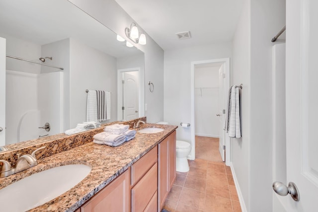 bathroom with vanity, walk in shower, tile patterned floors, and toilet