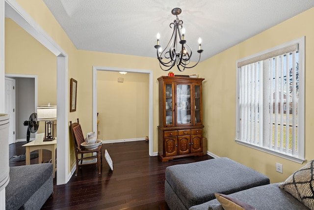 sitting room featuring dark hardwood / wood-style flooring, a notable chandelier, and a textured ceiling