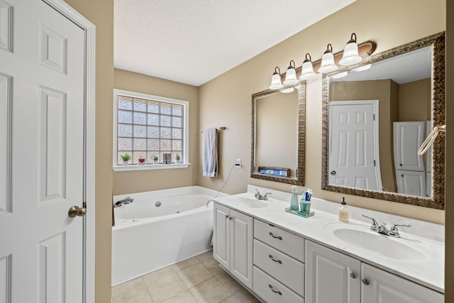 bathroom with vanity, a bath, tile patterned floors, and a textured ceiling