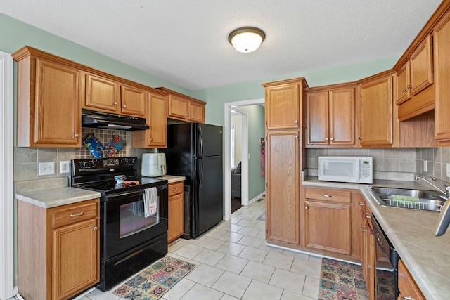 kitchen with sink, black appliances, a textured ceiling, light tile patterned floors, and backsplash