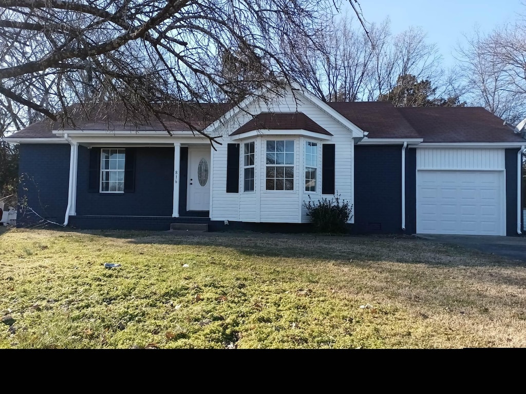 ranch-style home featuring a garage and a front lawn