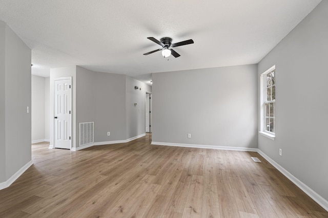 unfurnished room featuring ceiling fan, light hardwood / wood-style floors, and a textured ceiling