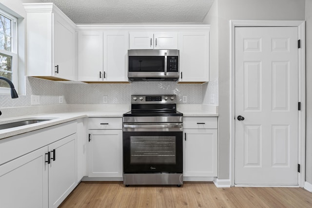 kitchen featuring appliances with stainless steel finishes, sink, and white cabinetry