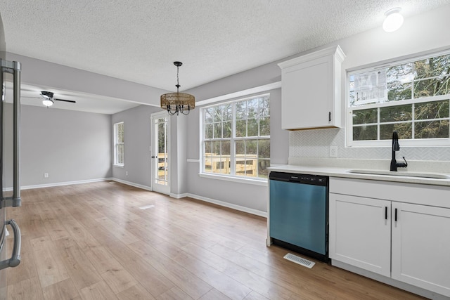 kitchen featuring sink, dishwasher, white cabinets, and light hardwood / wood-style floors