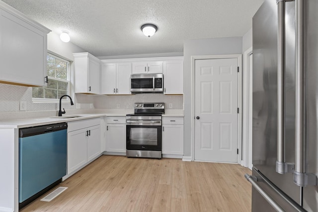 kitchen with sink, white cabinets, and stainless steel appliances