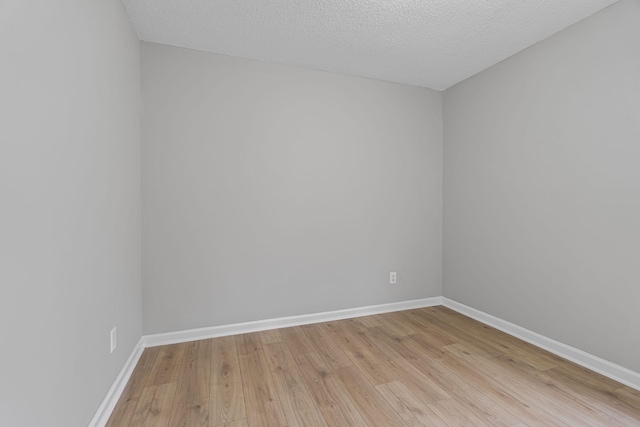 unfurnished room with light hardwood / wood-style floors and a textured ceiling