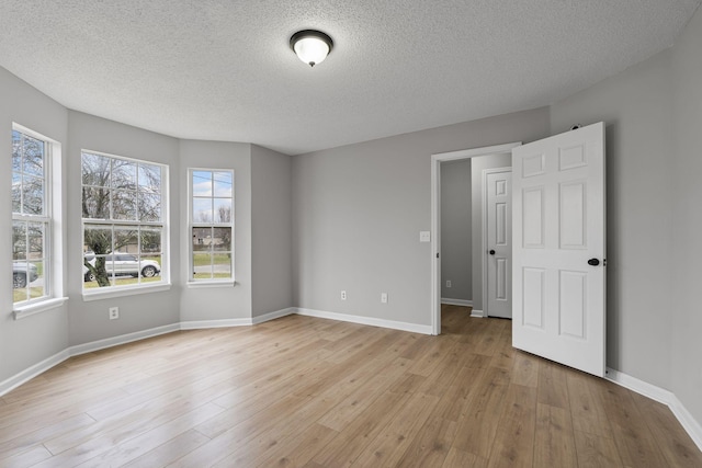 empty room featuring light hardwood / wood-style floors and a textured ceiling