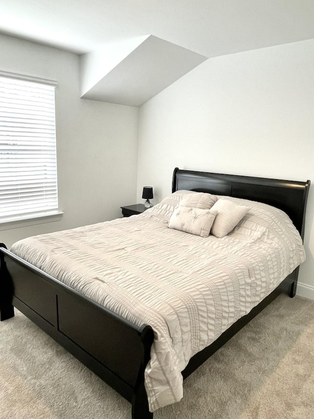 carpeted bedroom with lofted ceiling