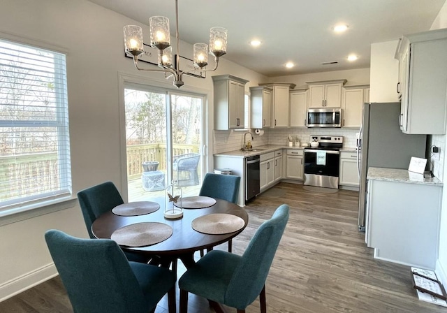 dining area featuring sink, a chandelier, and dark hardwood / wood-style floors