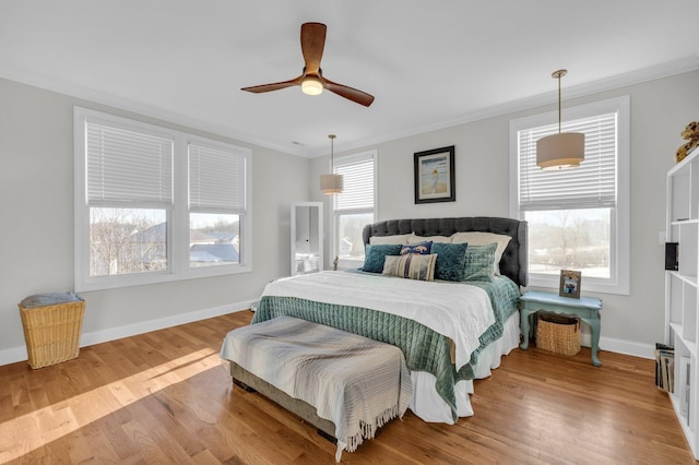 bedroom with ornamental molding, ceiling fan, and light hardwood / wood-style flooring