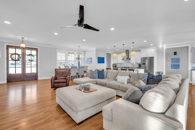 living room featuring ceiling fan, ornamental molding, and light hardwood / wood-style floors