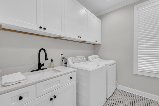 clothes washing area with sink, ornamental molding, cabinets, and washer and dryer