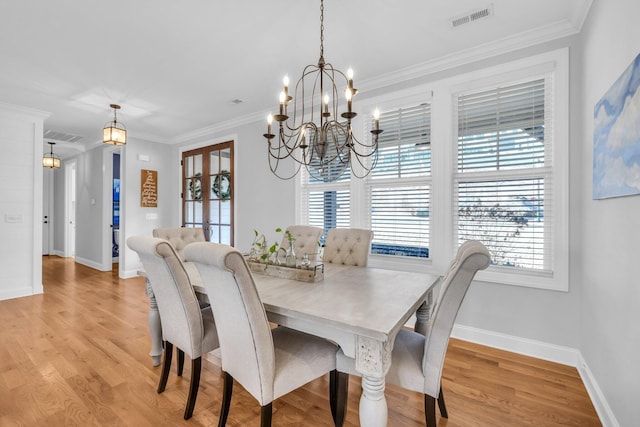 dining area with crown molding, french doors, and light wood-type flooring