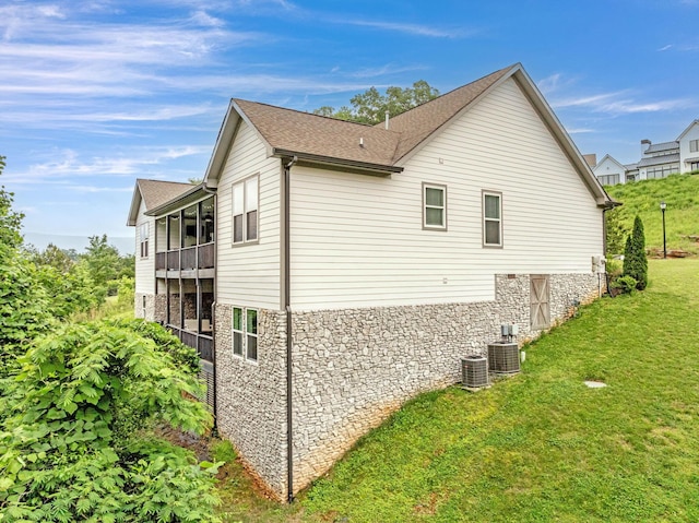 517 Kestrel Ln, Chattanooga, TN 37419 - view of side of home featuring stone siding, a balcony, a yard, cooling unit, and a shingled roof
