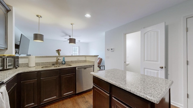 kitchen with pendant lighting, sink, a kitchen island, dark hardwood / wood-style flooring, and stainless steel dishwasher