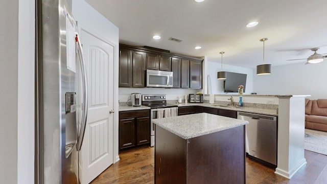 kitchen with a kitchen island, pendant lighting, sink, kitchen peninsula, and stainless steel appliances