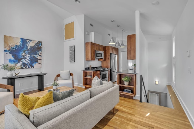 living room with light hardwood / wood-style flooring and high vaulted ceiling