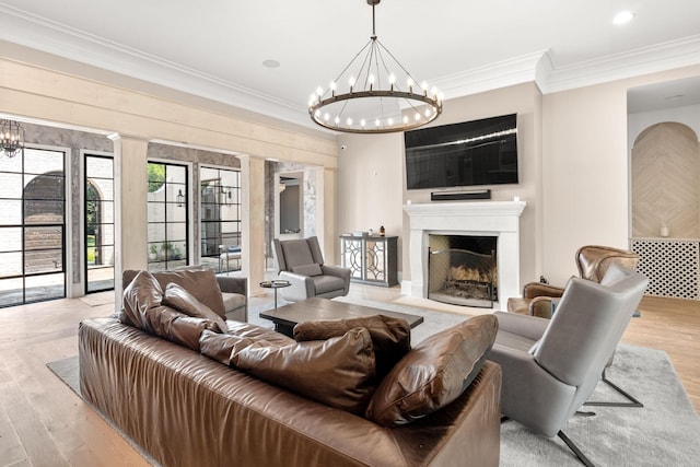 living room featuring crown molding, a chandelier, and light hardwood / wood-style floors